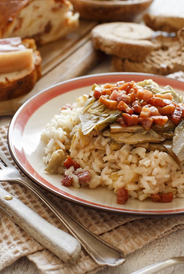 Risotto with artichokes and bacon top view on a wooden table