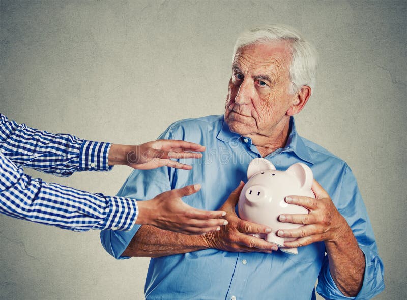 Risparmio proteggente sospettoso del porcellino salvadanaio della tenuta dell'uomo senior fotografie stock Risparmio proteggente sospettoso del porcellino salvadanaio della tenuta dell'uomo senior fotografie stock