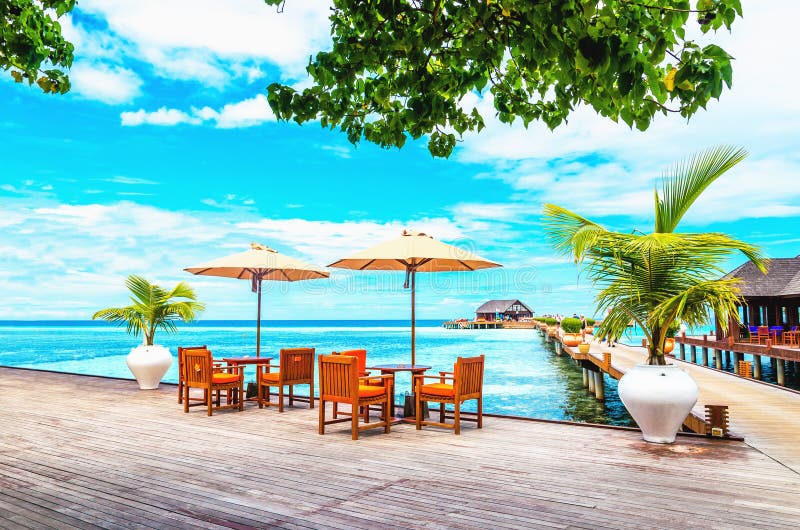 Ristorante con gli ombrelloni su un pilastro di legno contro l'acqua azzurrata dell'oceano fotografia stock libera da diritti Ristorante con gli ombrelloni su un pilastro di legno contro l'acqua azzurrata dell'oceano fotografia stock libera da diritti