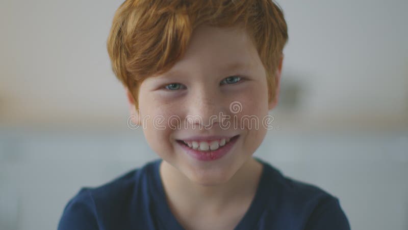 Ritratti di un piccolo rossastro allegro con le lentiggini che sorridono e posano con la telecamera stock footage