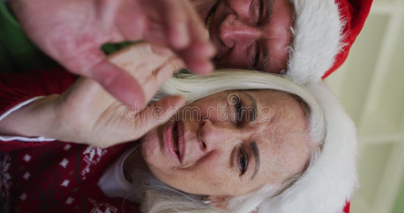 Ritratti laterali di una coppia caucasica felice e anziana che festeggia il natale indossando cappelli santa archivi video