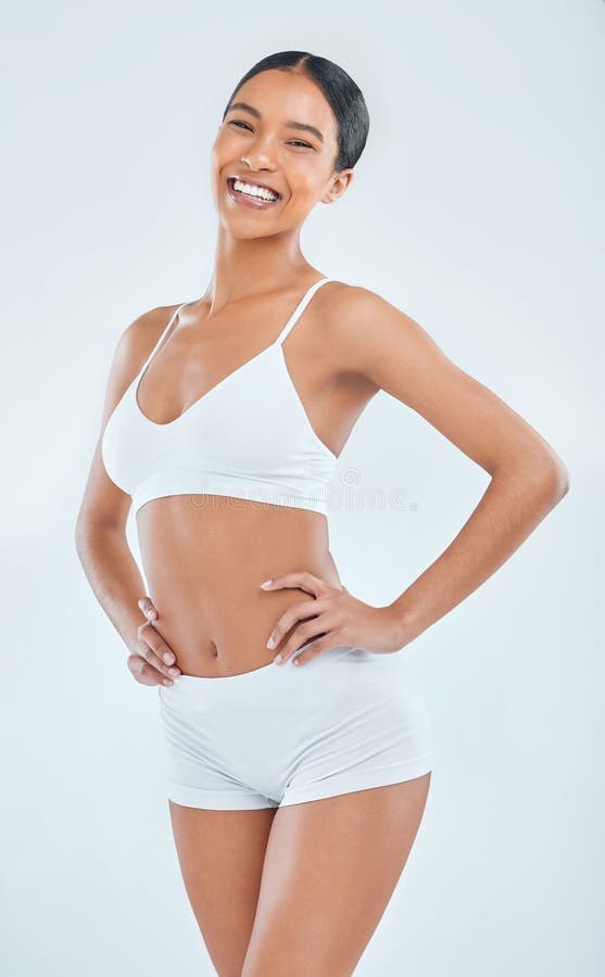 Ritratti, salute e stile di vita in studio in biancheria intima e nutrizione su fondo bianco. sorridere lo stomaco e fotografia stock