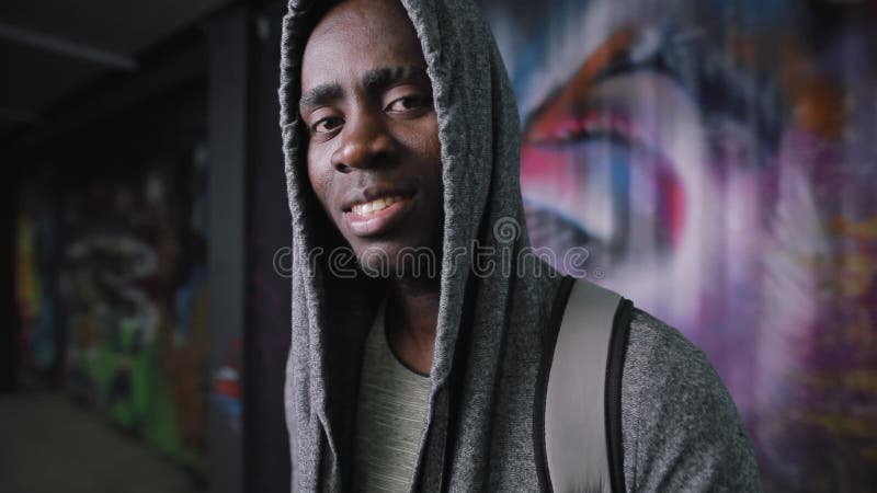 Ritratto afroamericano sorridente dell'uomo nel posto sotterraneo che esamina macchina fotografica