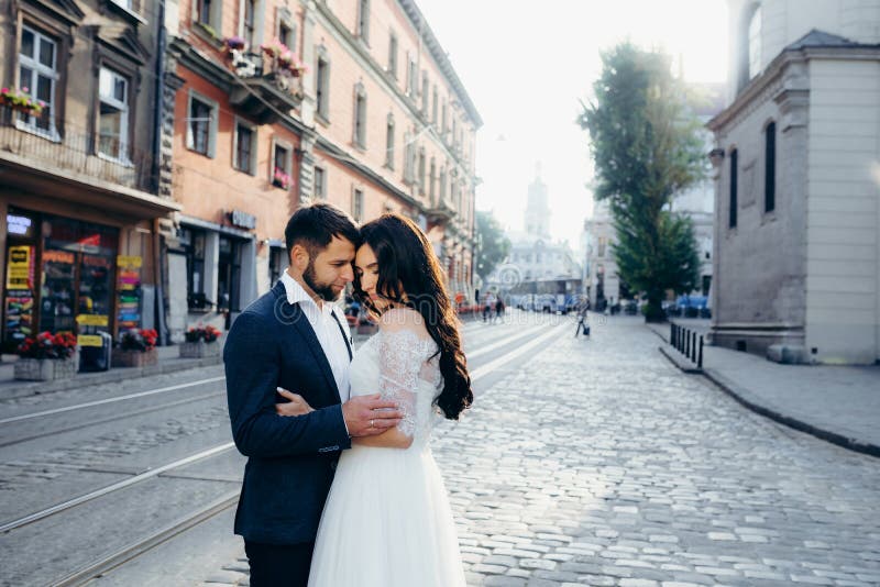 Ritratto all'aperto sensuale La coppia abbastanza giovane delle persone appena sposate sta abbracciando delicatamente nella via s immagini stock Ritratto all'aperto sensuale La coppia abbastanza giovane delle persone appena sposate sta abbracciando delicatamente nella via s immagini stock