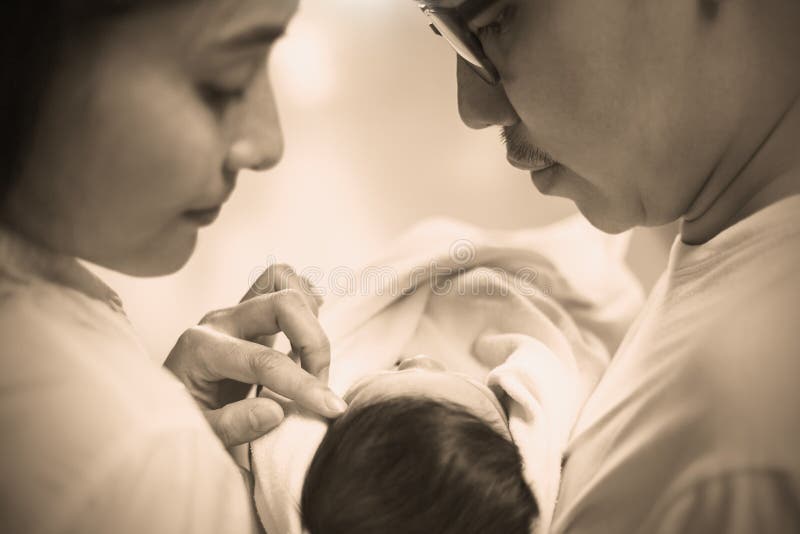Ritratto alto vicino di giovani coppie asiatiche che tengono il loro bambino neonato fotografie stock libere da diritti Ritratto alto vicino di giovani coppie asiatiche che tengono il loro bambino neonato fotografie stock libere da diritti