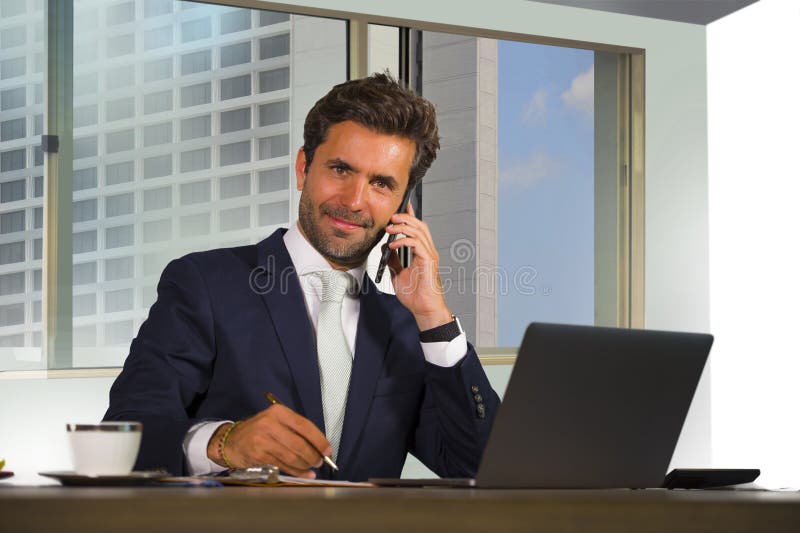 Ritratto corporativo di giovane uomo d'affari bello ed attraente felice che lavora allo scrittorio del computer in ufficio modern fotografie stock Ritratto corporativo di giovane uomo d'affari bello ed attraente felice che lavora allo scrittorio del computer in ufficio modern fotografie stock