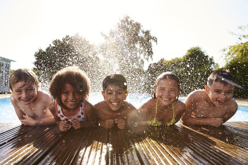 Ritratto dei bambini divertendosi nella piscina all'aperto fotografia stock Ritratto dei bambini divertendosi nella piscina all'aperto fotografia stock