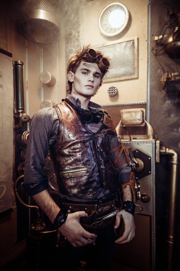 Ritratto dei vetri d'uso di un giovane uomo dello steampunk con il mechanica fotografia stock libera da diritti Ritratto dei vetri d'uso di un giovane uomo dello steampunk con il mechanica fotografia stock libera da diritti