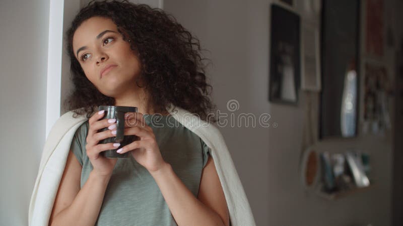 Ritratto del caffè bevente o del tè della donna pensierosa a casa immagine stock libera da diritti Ritratto del caffè bevente o del tè della donna pensierosa a casa immagine stock libera da diritti