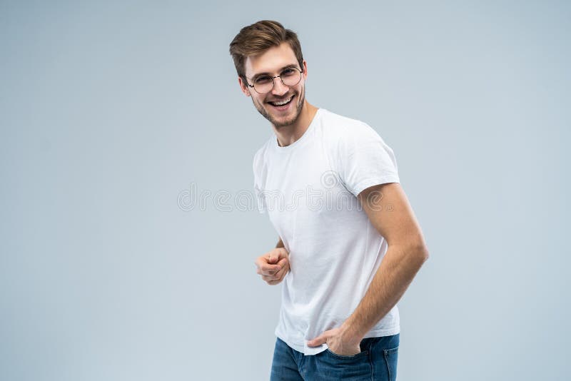 Ritratto del giovane bello con il sorriso di orientamento su fondo grigio immagini stock libere da diritti Ritratto del giovane bello con il sorriso di orientamento su fondo grigio immagini stock libere da diritti