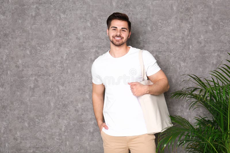 Ritratto del giovane con la borsa di eco nella pianta dell'interno della palma immagini stock libere da diritti Ritratto del giovane con la borsa di eco nella pianta dell'interno della palma immagini stock libere da diritti