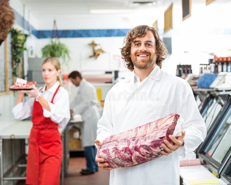 Ritratto del macellaio felice Holding Meat Package fotografie stock libere da diritti Ritratto del macellaio felice Holding Meat Package fotografie stock libere da diritti