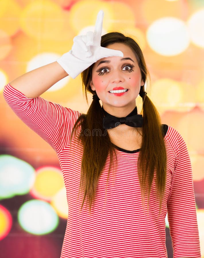 Ritratto del primo piano del mimo femminile del pagliaccio che gesturing perdente con le dita fotografia stock Ritratto del primo piano del mimo femminile del pagliaccio che gesturing perdente con le dita fotografia stock