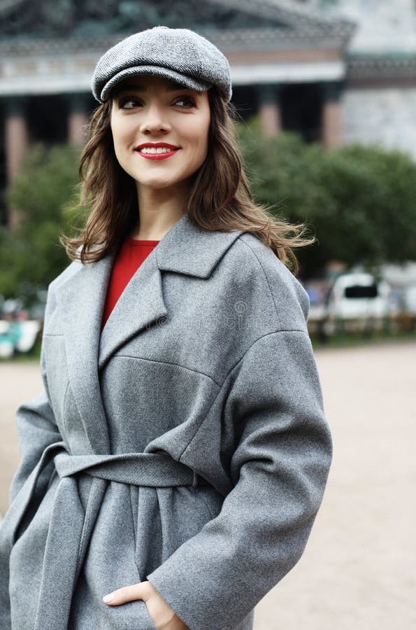 Ritratto del primo piano della giovane donna nella condizione grigia elegante del cappotto sulla via nel giorno di autunno fotografie stock Ritratto del primo piano della giovane donna nella condizione grigia elegante del cappotto sulla via nel giorno di autunno fotografie stock