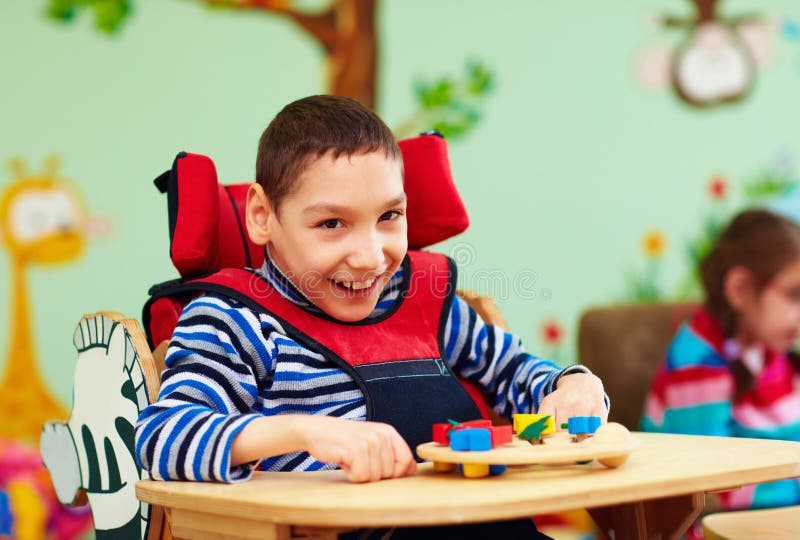 Ritratto del ragazzo allegro con l'inabilità al centro di riabilitazione per i bambini con i bisogni speciali