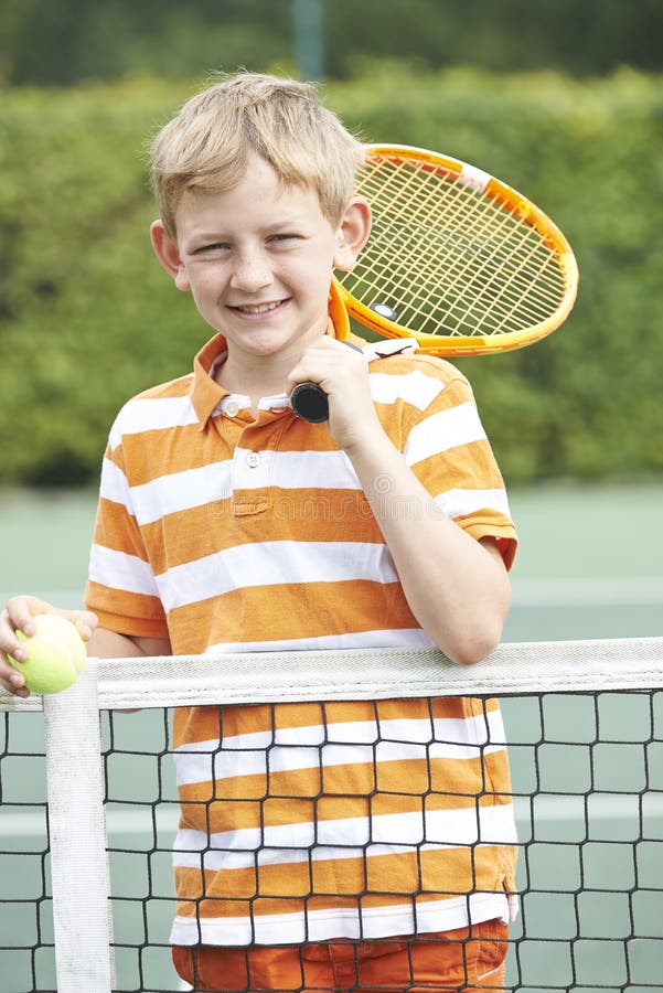 Ritratto del ragazzo che gioca a tennis che sta accanto alla rete