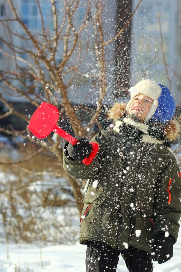 Ritratto del ragazzo felice caucasico di sette anni che gioca con la prima neve di inverno immagini stock libere da diritti Ritratto del ragazzo felice caucasico di sette anni che gioca con la prima neve di inverno immagini stock libere da diritti