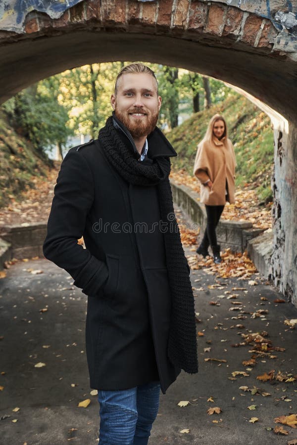 Ritratto del tipo sorridente della testarossa sotto il vecchio arco del ponte immagini stock libere da diritti Ritratto del tipo sorridente della testarossa sotto il vecchio arco del ponte immagini stock libere da diritti
