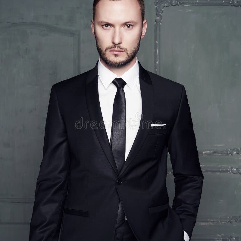 Ritratto dell'uomo alla moda bello in vestito nero elegante fotografia stock Ritratto dell'uomo alla moda bello in vestito nero elegante fotografia stock