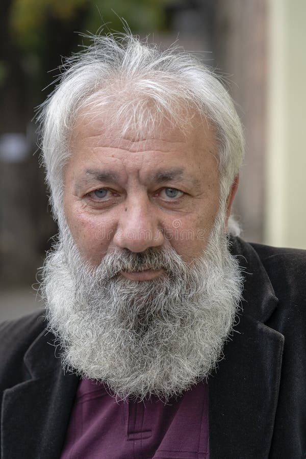 Ritratto dell'uomo anziano con una barba grigia in una chiesa ortodossa russa nel centro di Tbilisi, Georgia fotografia stock libera da diritti Ritratto dell'uomo anziano con una barba grigia in una chiesa ortodossa russa nel centro di Tbilisi, Georgia fotografia stock libera da diritti
