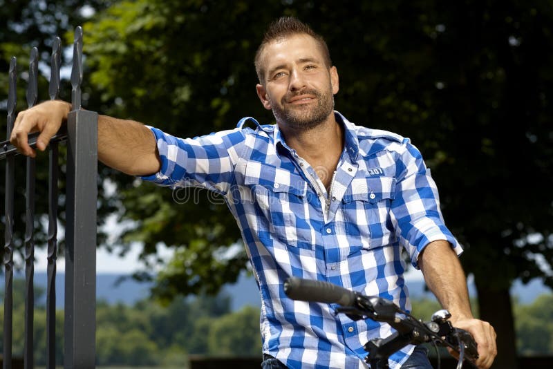 Ritratto dell'uomo casuale felice sulla bicicletta all'aperto immagini stock libere da diritti Ritratto dell'uomo casuale felice sulla bicicletta all'aperto immagini stock libere da diritti