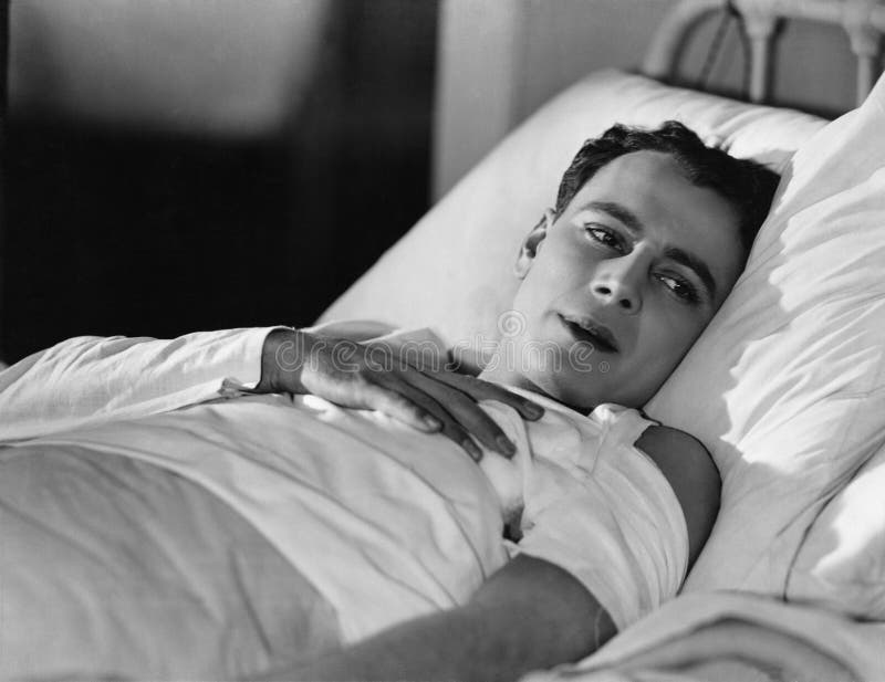Ritratto dell'uomo danneggiato a letto immagine stock Ritratto dell'uomo danneggiato a letto immagine stock