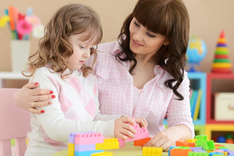 Ritratto della bambina riccia con il gioco della madre immagini stock