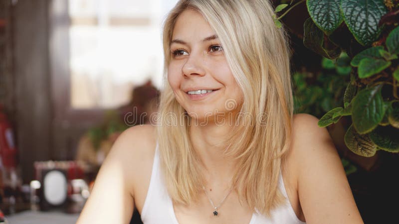 Ritratto della bionda sorridente che si siede alla caffetteria fotografia stock libera da diritti Ritratto della bionda sorridente che si siede alla caffetteria fotografia stock libera da diritti
