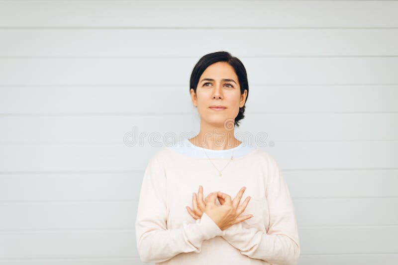 Ritratto della donna che tiene mudra gyan accanto al cuore fotografia stock libera da diritti Ritratto della donna che tiene mudra gyan accanto al cuore fotografia stock libera da diritti