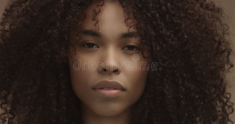 Ritratto della donna di colore della corsa mista con i grandi capelli di afro, capelli ricci