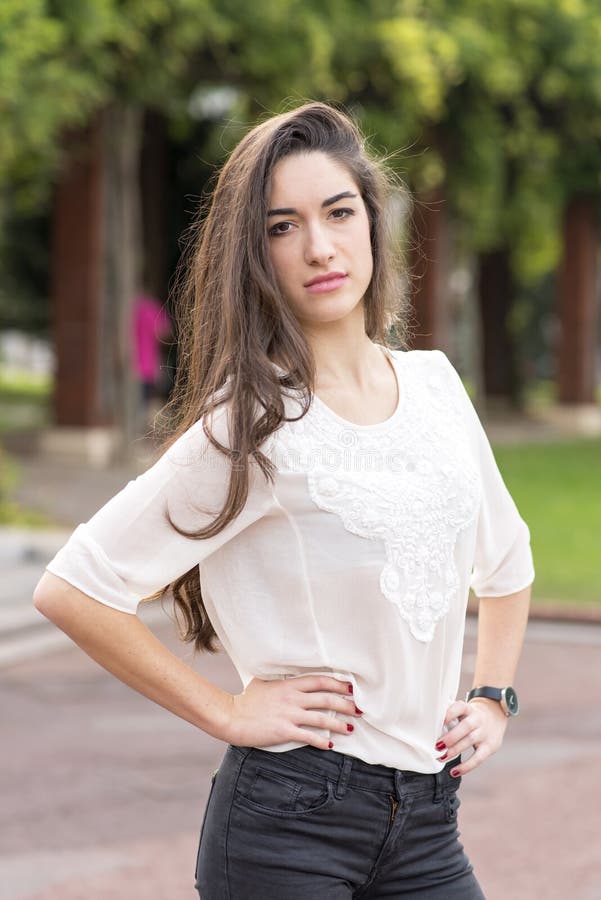 Ritratto della donna elegante di Brunete nel parco immagine stock Ritratto della donna elegante di Brunete nel parco immagine stock
