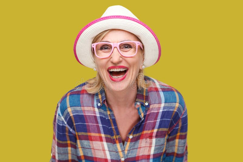 Ritratto della donna matura alla moda moderna felice nello stile casuale con il cappello e gli occhiali che stanno e che esaminan immagini stock Ritratto della donna matura alla moda moderna felice nello stile casuale con il cappello e gli occhiali che stanno e che esaminan immagini stock