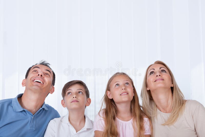 Ritratto della famiglia con due bambini che osservano in su fotografia stock libera da diritti Ritratto della famiglia con due bambini che osservano in su fotografia stock libera da diritti