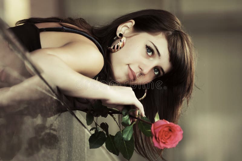 Portrait of sad young fashion woman with red rose daydreaming. Portrait of sad young fashion woman with red rose daydreaming