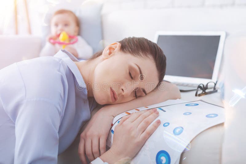 Ritratto della mamma sonnolenta che mette testa sul suo braccio immagine stock libera da diritti Ritratto della mamma sonnolenta che mette testa sul suo braccio immagine stock libera da diritti