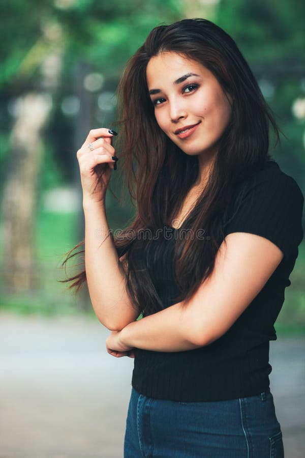 Ritratto della ragazza asiatica dei bei capelli lunghi felici in maglietta nera sulla via fotografia stock libera da diritti Ritratto della ragazza asiatica dei bei capelli lunghi felici in maglietta nera sulla via fotografia stock libera da diritti