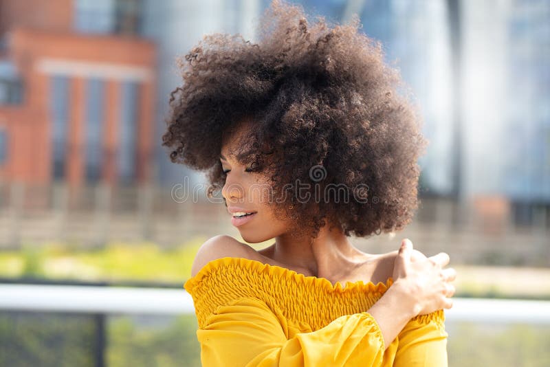 Ritratto della ragazza di afro nella città fotografie stock libere da diritti Ritratto della ragazza di afro nella città fotografie stock libere da diritti