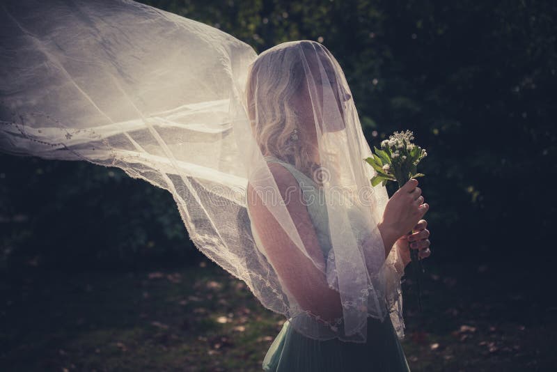 Ritratto della sposa con il velo e mazzo dei fiori selvaggi all'aperto fotografie stock Ritratto della sposa con il velo e mazzo dei fiori selvaggi all'aperto fotografie stock