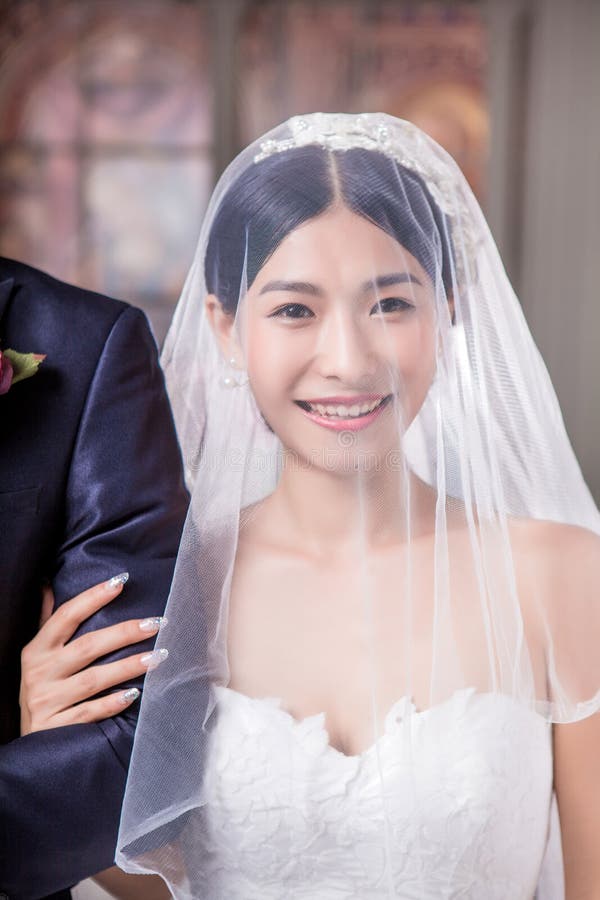 Ritratto della sposa felice che sta con lo sposo in chiesa fotografia stock Ritratto della sposa felice che sta con lo sposo in chiesa fotografia stock