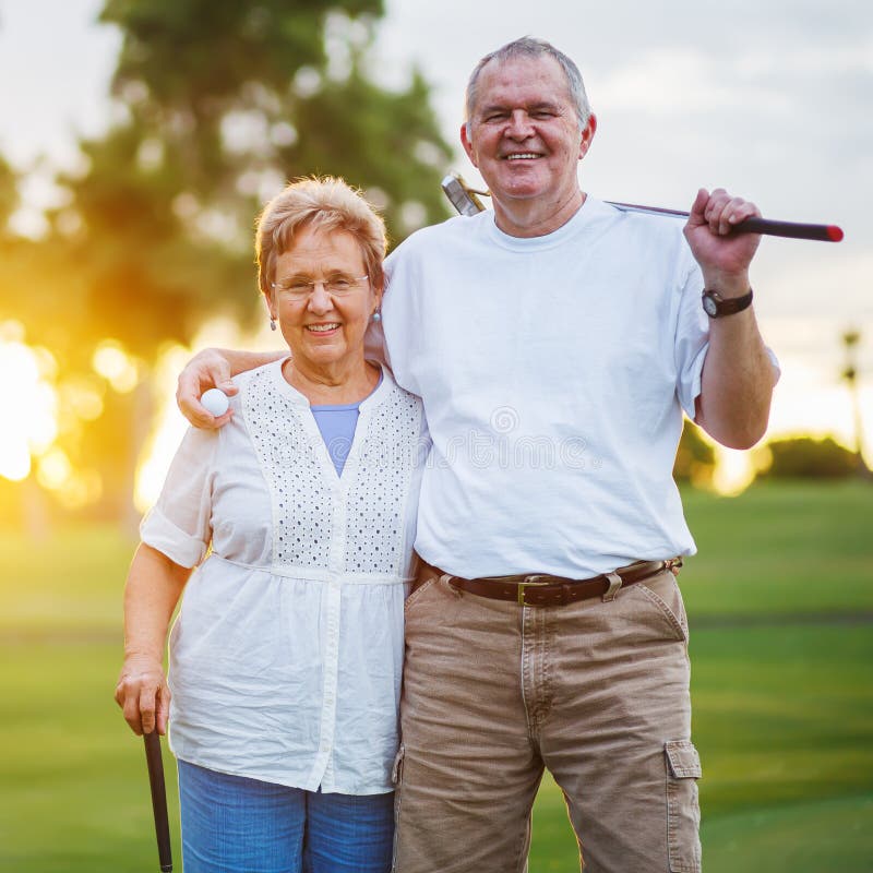 Ritratto delle coppie senior felici che giocano golf che gode del pensionamento immagini stock libere da diritti Ritratto delle coppie senior felici che giocano golf che gode del pensionamento immagini stock libere da diritti