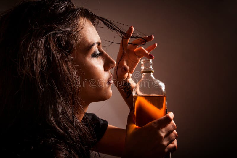 Ritratto di bella donna con la bottiglia della bevanda dell'alcool fotografie stock Ritratto di bella donna con la bottiglia della bevanda dell'alcool fotografie stock