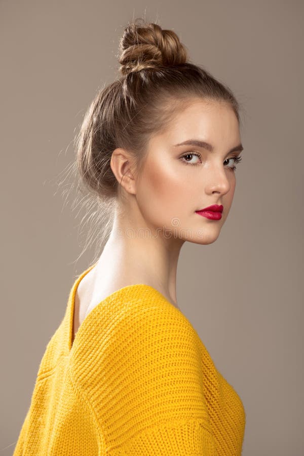 Ritratto di bella donna con trucco su un fondo grigio Maglione arancione fotografie stock Ritratto di bella donna con trucco su un fondo grigio Maglione arancione fotografie stock