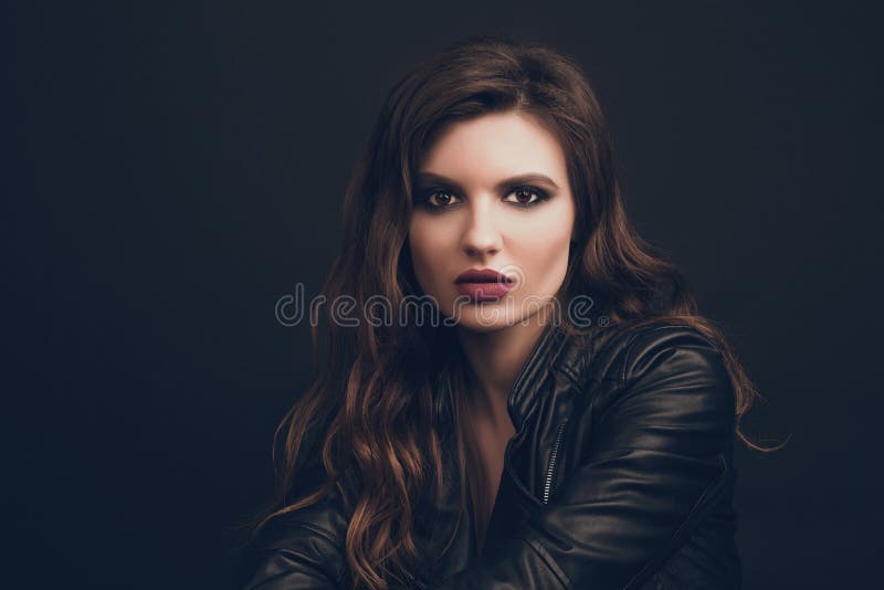 Ritratto di bella giovane donna con capelli marroni ondulati che posano allo studio sopra fondo nero modificato immagine stock Ritratto di bella giovane donna con capelli marroni ondulati che posano allo studio sopra fondo nero modificato immagine stock