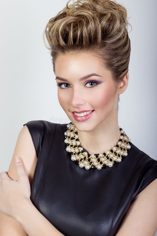 ritratto di bella giovane donna sexy felice che sorride in un vestito da sera nero con capelli e nel trucco con gioielli costosi fotografia stock libera da diritti ritratto di bella giovane donna sexy felice che sorride in un vestito da sera nero con capelli e nel trucco con gioielli costosi fotografia stock libera da diritti