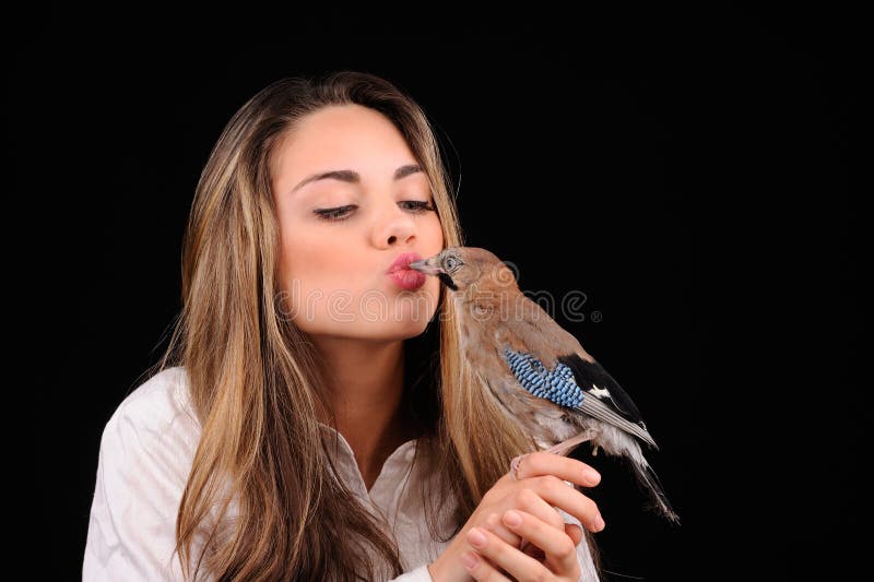 Ritratto di bella ragazza con uccello in mano