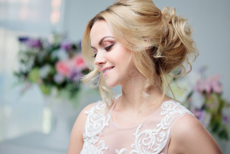 Ritratto di bella ragazza in un vestito da sposa Sposa in un vestito lussuoso su un fondo bianco, bella acconciatura fotografia stock Ritratto di bella ragazza in un vestito da sposa Sposa in un vestito lussuoso su un fondo bianco, bella acconciatura fotografia stock
