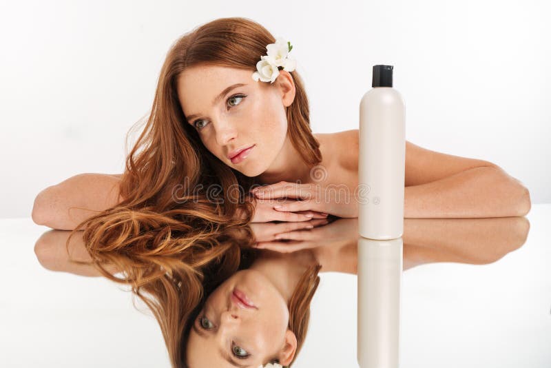 Ritratto di bellezza della donna dello zenzero con il fiore in capelli immagine stock libera da diritti Ritratto di bellezza della donna dello zenzero con il fiore in capelli immagine stock libera da diritti