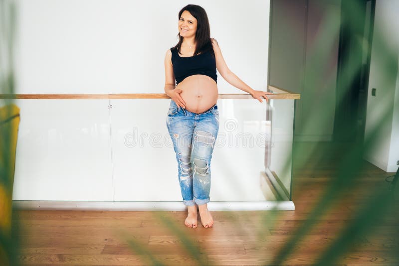 Ritratto di bello giovane bambino sorridente ed aspettante della donna incinta Lisciando pancia e previsione del concetto fotografie stock libere da diritti Ritratto di bello giovane bambino sorridente ed aspettante della donna incinta Lisciando pancia e previsione del concetto fotografie stock libere da diritti