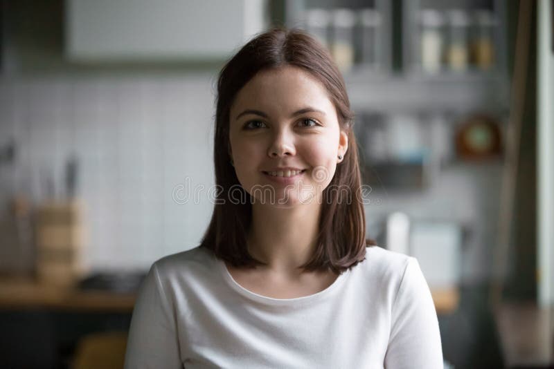 Ritratto di colpo in testa della donna millenaria sorridente che posa a casa corredo immagine stock libera da diritti Ritratto di colpo in testa della donna millenaria sorridente che posa a casa corredo immagine stock libera da diritti