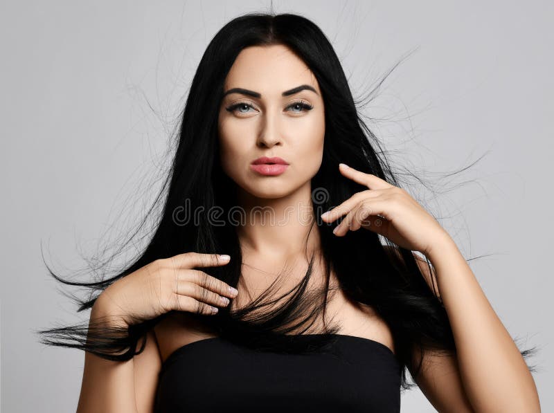 Ritratto di concetto della pubblicità della donna castana spazzolando delicato i suoi capelli perfetti che fluttuano nel vento co fotografia stock Ritratto di concetto della pubblicità della donna castana spazzolando delicato i suoi capelli perfetti che fluttuano nel vento co fotografia stock